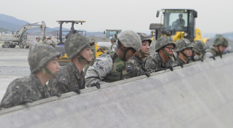 U.S. and Republic of Korea Airmen lift a rapid-runway repair fiberglass mat during the U.S./ROK Combined Airfield Damage Repair Exercise at Daegu Air Base, April 20, 2017. For five days, U.S. and ROK Airmen repaired damaged runway sections sharing techniques, strengthening bonds and forging friendships between the two allied countries. (U.S. Air Force photo by Staff Sgt. Alex Fox Echols III)