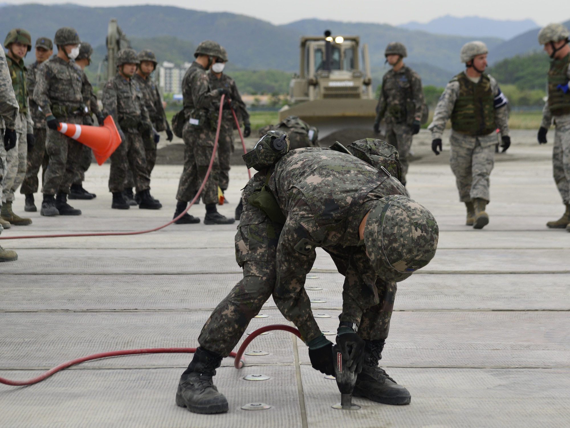 A Republic of Korea Airman secures a rapid-runway repair fiberglass mat during the U.S./ROK Combined Airfield Damage Repair Exercise at Daegu Air Base, April 20, 2017. After the mat is set up, Airmen place it over sections of damaged runway to ensure a safe launch and recovery of aircraft. (U.S. Air Force photo by Staff Sgt. Alex Fox Echols III)