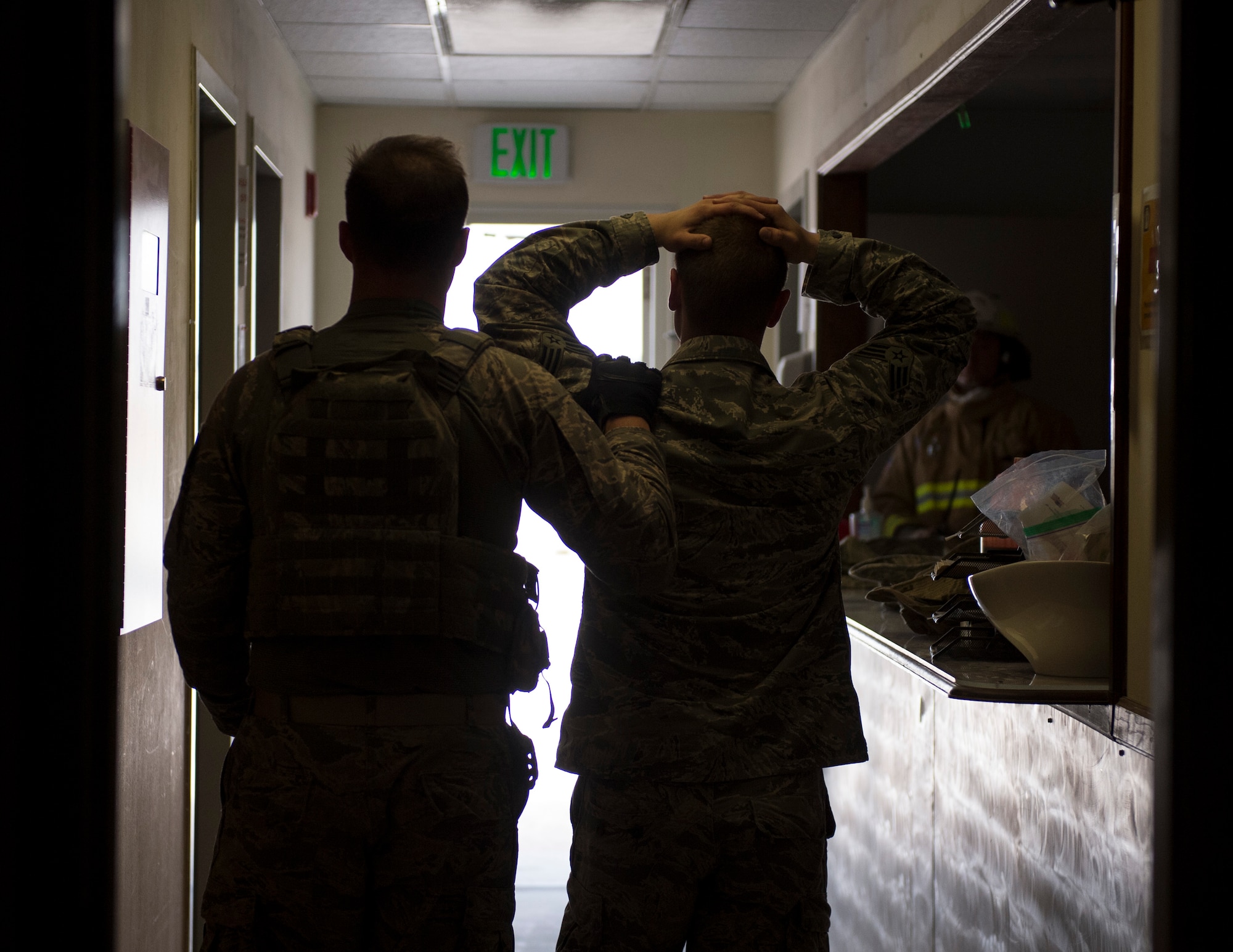 A member of the 379th Expeditionary Security Forces Squadron, left, escorts a role player out of a building at Al Udeid Air Base, Qatar, April 17, 2017. The active shooter exercise tested the skills and abilities of Airmen to work with other units in in order to gain a better understanding of each other’s roles in the event of a real-world situation.   (U.S. Air Force photo by Tech. Sgt. Amy M. Lovgren)
