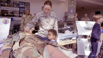 Sgt. Pattisue Graham, a member of the Medical Support Unit - Europe, explains a CPR mannequin to a child Friday, April 21 at the Kaiserslautern Military Community Center on Ramstein Air Base. Her units, part of the Army Reserve's 7th Mission Support Command, was celebrating the 109th Army Reserve birthday during the event. 