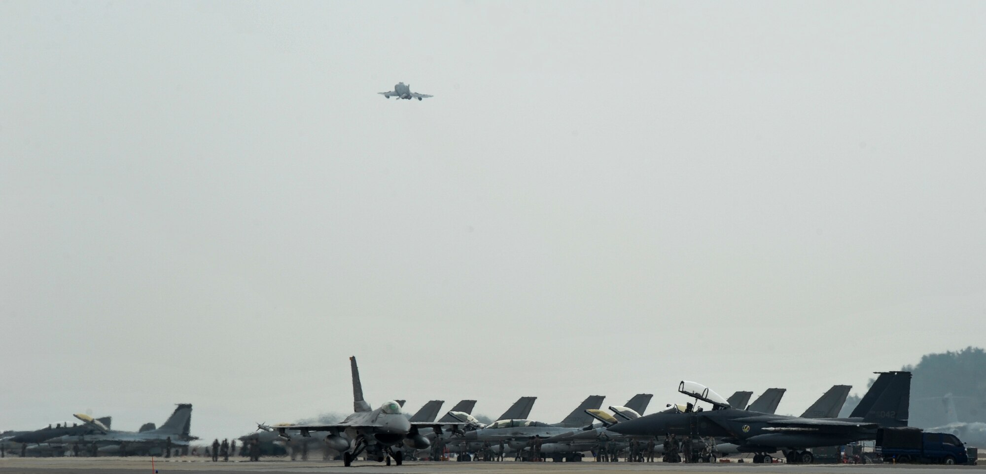 An F-16 Fighting Falcon from the 80th Fighter Squadron taxis down the flightline while a McDonnell F-4E Phantom II jet from the 17th Fighter Squadron, Chung Ju Air Base, Republic of Korea, takes off during Exercise MAX THUNDER 17 at Kunsan Air Base, Republic of Korea, April 18, 2017. In Max Thunder, U.S. and ROK air forces consistently train together to be ready around-the-clock to defend the Republic of Korea. (U.S. Air Force photo by Senior Airman Colville McFee/Released)