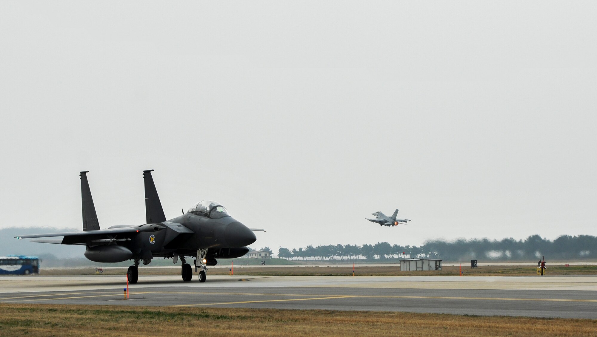 A Republic of Korea Air Force F-15K Slam Eagles from the 11th Fighter Squadron, Daegu Air Base, ROK, taxis down the flightline while an F-16 Fighting Falcon from the 35th Fighter Squadron takes off during Exercise MAX THUNDER 17 at Kunsan Air Base, Republic of Korea, April 18, 2017. In Max Thunder, U.S. and ROK air forces consistently train together to be ready around-the-clock to defend the Republic of Korea. The interoperability and trust developed between the allies in training is critical to ensure we are prepared for any challenge. (U.S. Air Force photo by Senior Airman Colville McFee/Released)