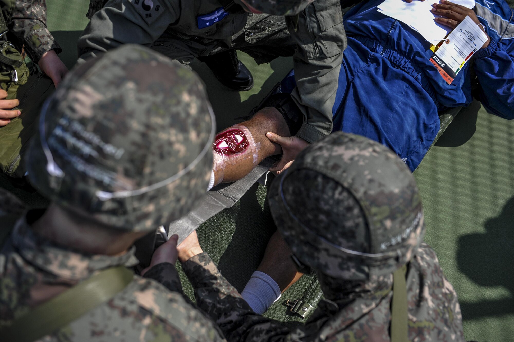 United States Air Force Staff Sgt. Devon Jefferies, 8th Medical Logistics Squadron medical technician, lies on a stretcher while receiving care from Republic of Korea Air Force airmen during a mass casualty exercise at Kunsan Air Base, Republic of Korea, April 19, 2017. U.S. and ROK airmen conducted the training to evaluate their ability to communicate and operate through a MASCAL situation. (U.S. Air Force photo by Senior Airman Colville McFee/Released)