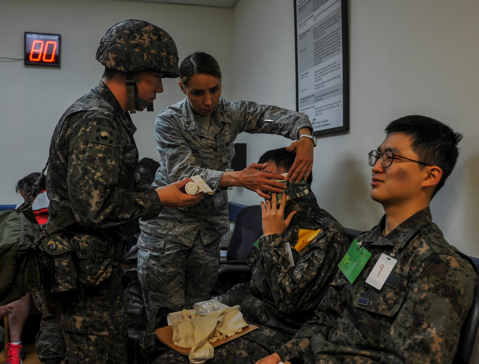 United States Air Force Maj. Anna Fedotova, 8th Medical Operation Squadron mental health flight chief, and a Republic of Korea Air Force medical airman work together to bandage a ROKAF airman’s head during a mass casualty exercise at Kunsan Air Base, Republic of Korea, April 19, 2017. U.S. and ROK airmen conducted the training to evaluate their ability to communicate and operate through a MASCAL situation. (U.S. Air Force photo by Senior Airman Colville McFee/Released)