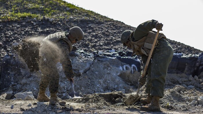 U.S. Marine Corps Gunnery Sgt. Myron Sato, left, the combat engineer staff-non-commissioned-officer-in-charge for Marine Wing Support Squadron 171, and Pfc. Jason Taylor, right a combat engineer with MWSS-171, shovel dirt and mud during airfield damage and repair training at Marine Corps Air Station Iwakuni, Japan, April 19, 2017. The ADR training required Marines to utilize their skill set to tactically and proficiently fix any anomalies to a simulated damaged airfield. The training focused on becoming more efficient in situations that may require Marines to act in real-world scenarios to maintain the tempo of aircraft operations. 