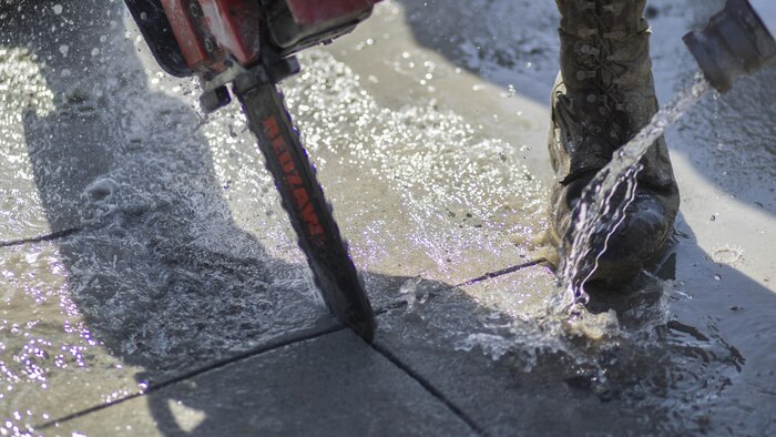 Water cools a chainsaw as it cuts through concrete during airfield damage and repair training at Marine Corps Air Station Iwakuni, Japan, April 19, 2017. The ADR training required Marines to utilize their skill set to tactically and proficiently fix any anomalies to a simulated damaged airfield. The training focused on becoming more efficient in situations that may require Marines to act in real-world scenarios to maintain the tempo of aircraft operations.