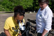 Susan L. Hooks, forest botanist, Ouachita and Ozark-St. Francis National Forests, assists a middle-school student from the Flightline Academy Charter School exam pollen samples at the Arnold Drive Elementary School Earth Day Expo April 20, 2017, at Little Rock Air Force Base, Ark. President Theodore Roosevelt established The Arkansas National Forest on December 18, 1907, and it is the oldest national forest in the South. On April 29, 1926, the forest was renamed as the Ouachita National Forest. (U.S. Air Force photo by Master Sgt. Jeff Walston/Released)