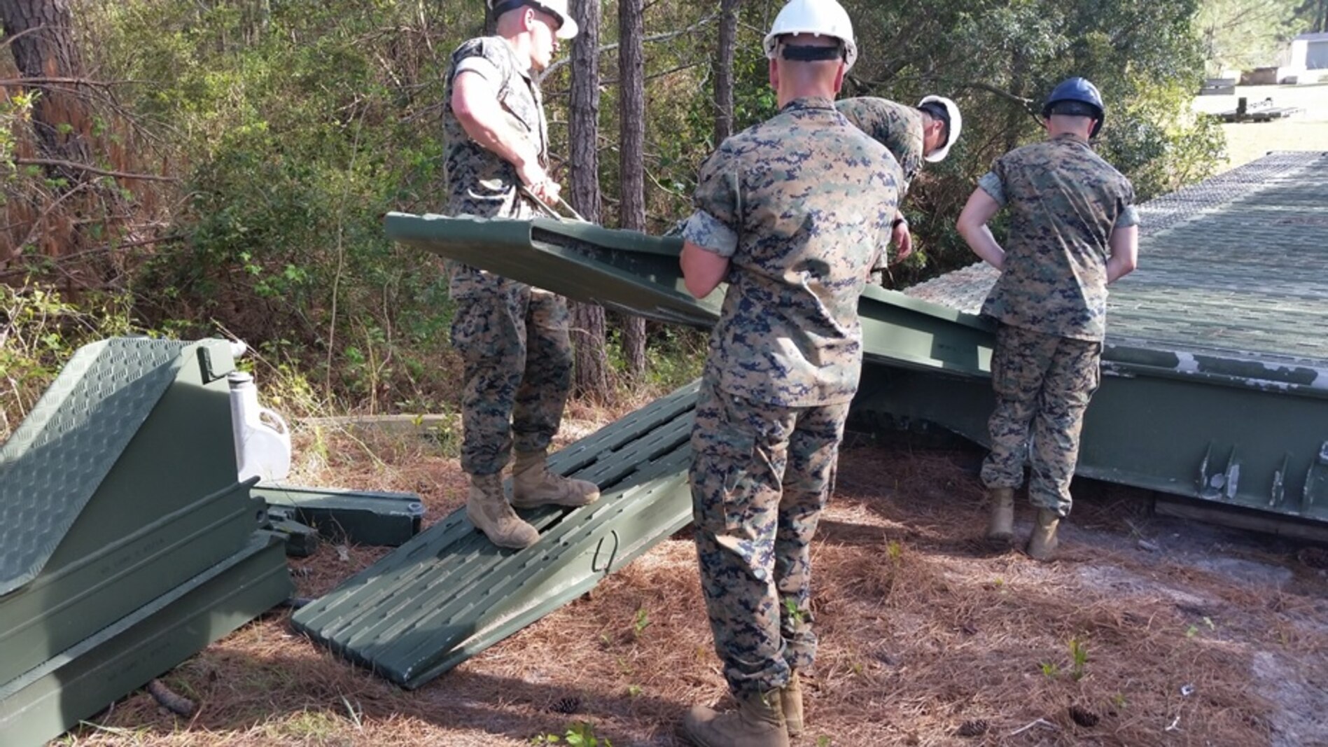 On April 10, 2017, Marines attached to Combat Engineer Officer course 3-17 (CEO 3-17) emplace ramp units on a single story medium girder bridge. During their period of instruction, CEO students learn to employ single story, double story, and double story with link reinforcement system medium girder bridges; in order to plan for troop movement across gaps. Pictured from left to right:  Second Lieutenants Jacob Ridings, Shawn Balent, Reynaldo Gutierrez, and Joshua Raphaelson.
