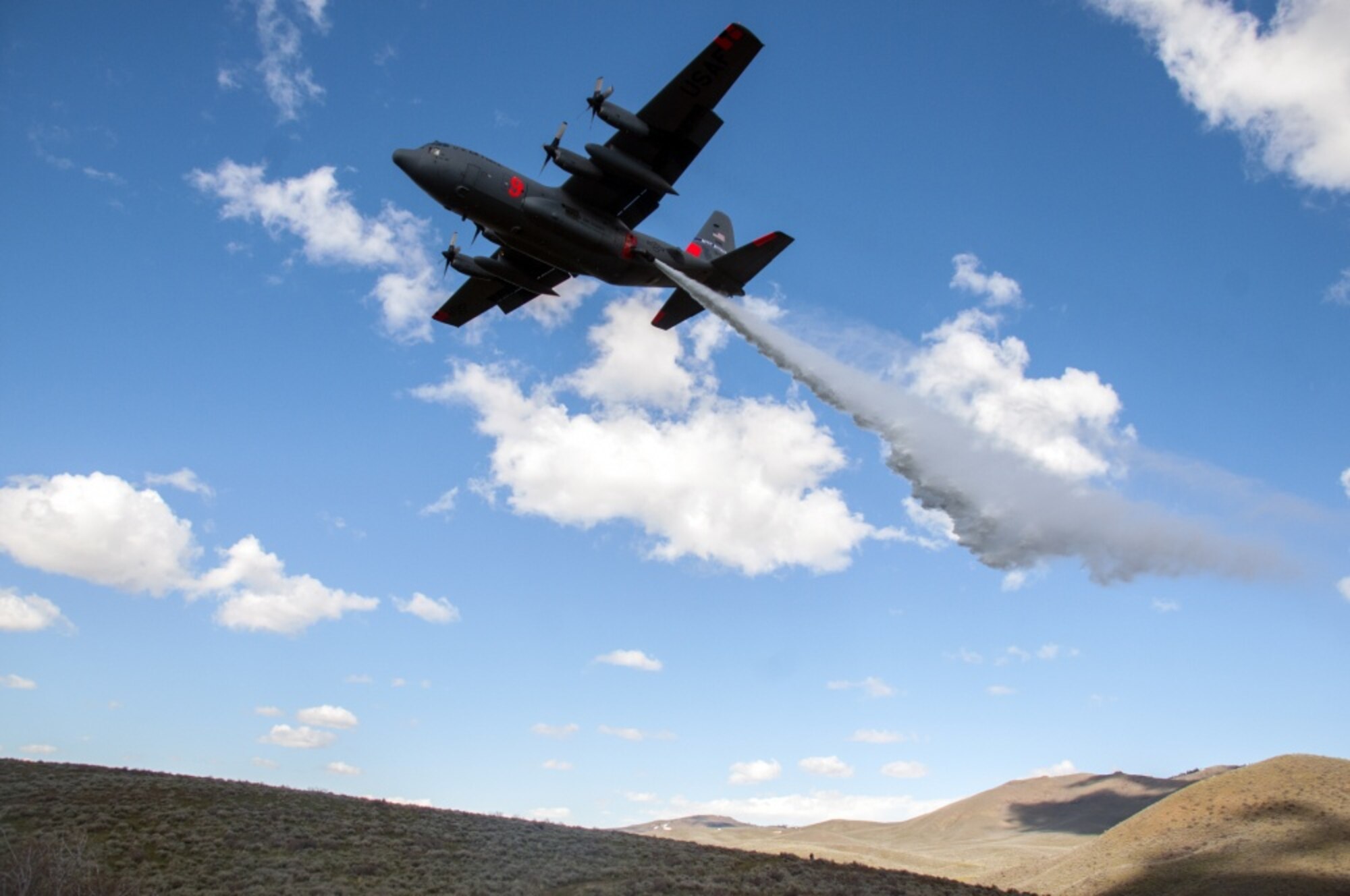 A C-130 with the 152nd Airlift Wing, Nevada Air National Guard, drops water in the mountains east of Boise, Idaho as part of the annual Modular Airborne Fire Fighting System training and certification, April 21, 2017. More than 400 personnel of four C-130 Guard and Reserve units — from California, Colorado, Nevada and Wyoming, making up the Air Expeditionary Group — are in Boise for the week-long wildfire training and certification sponsored by the U.S. Forest Service. (U.S. Air Force photo by Tech. Sgt. Emerson Marcus)

