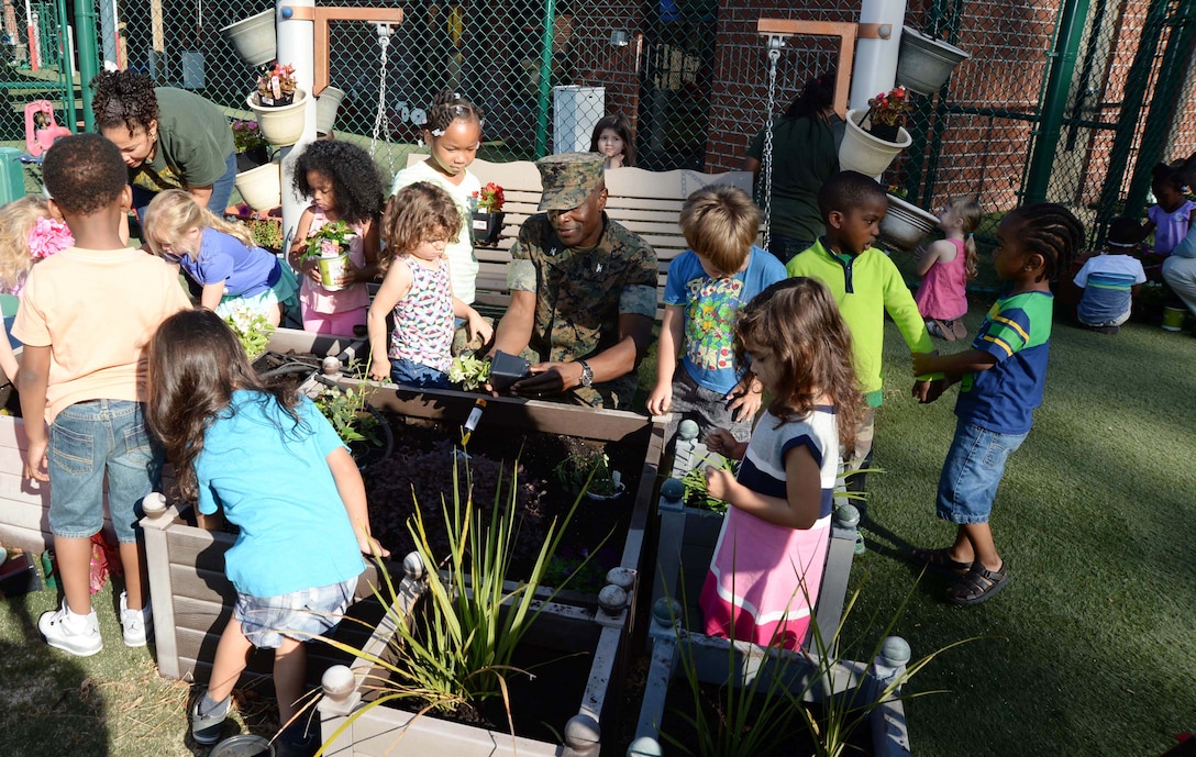 Col. James C. Carroll III (center), commanding officer, Marine Corps Logistics Base Albany, joins students and personnel at the installation’s Child Development Center for the 2017 Earth Day observance, here, April 21. The annual event teaches young scholars the importance of preserving the environment through planting and caring for flowers as well as fruit-bearing bushes around the perimeter of the children’s playground.