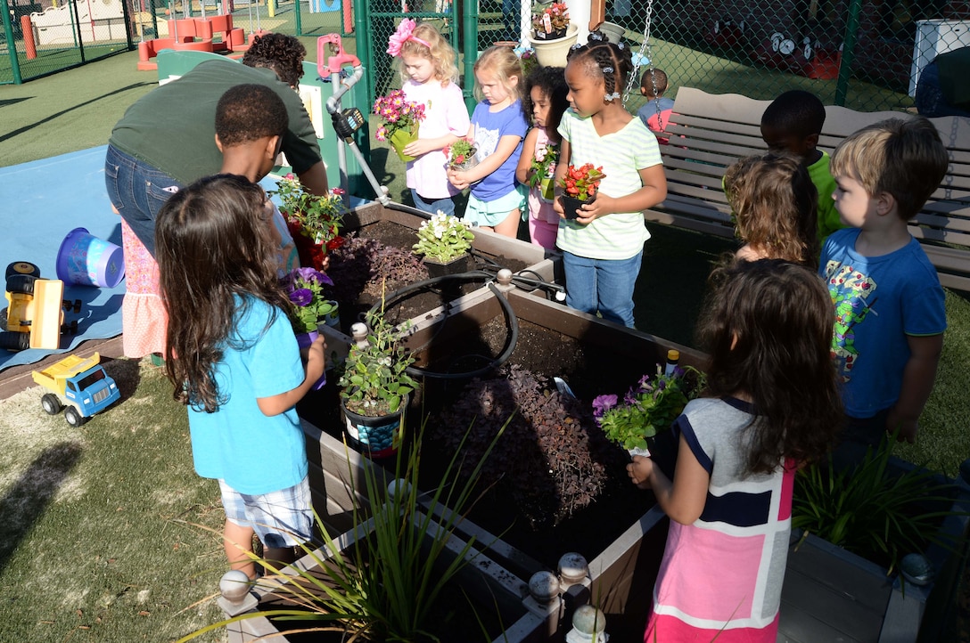 Students and personnel at the Child Development Center, aboard Marine Corps Logistics Base Albany, plant flowers as well fruit-bearing bushes in observance of the 2017 Earth Day, here, April 21. The annual event teaches young scholars about the importance of preserving the environment through planting and caring for the foliage, which they have planted in containers situated around the perimeter of the children’s playground.