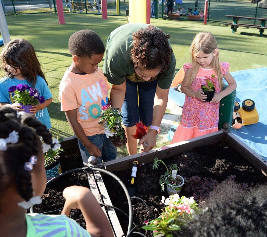 Students and personnel at the Child Development Center, aboard Marine Corps Logistics Base Albany, plant flowers as well fruit-bearing bushes in observance of the 2017 Earth Day, here, April 21. The annual event teaches young scholars about the importance of preserving the environment through planting and caring for the foliage, which they have planted in containers situated around the perimeter of the children’s playground.