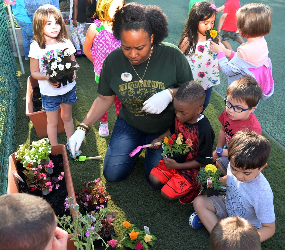 Students and personnel at the Child Development Center, aboard Marine Corps Logistics Base Albany, plant flowers as well fruit-bearing bushes in observance of the 2017 Earth Day, here, April 21. The annual event teaches young scholars about the importance of preserving the environment through planting and caring for the foliage, which they have planted in containers situated around the perimeter of the children’s playground.