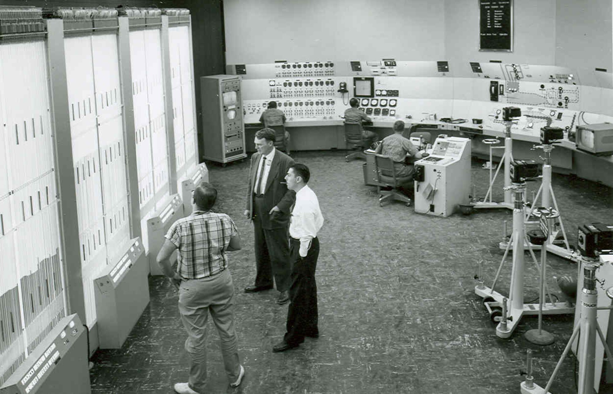 This 1957 photo of the Main Control Room-for the Propulsion Wind Tunnel’s transonic circuit shows manometer banks at left, for recording pressures from the tunnel’s test section. At the far rear is a closed-circuit television monitor which shows the test item on its screen. The tunnel’s chief operator is seated in the center of the room. (AEDC photo)