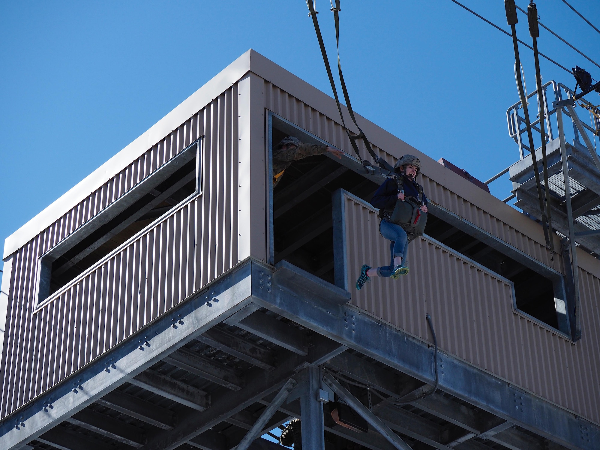 Eagle River High School Air Force Junior ROTC Cadet Riley Sheldon exits a 34-foot jump tower April 19, 2017, at the Joint Base Elmendorf-Richardson Airborne Sustainment Training Area. Sheldon is the daughter of Sgt. Maj. Ronald Sheldon, the 673d Air Base Wing sergeant major.