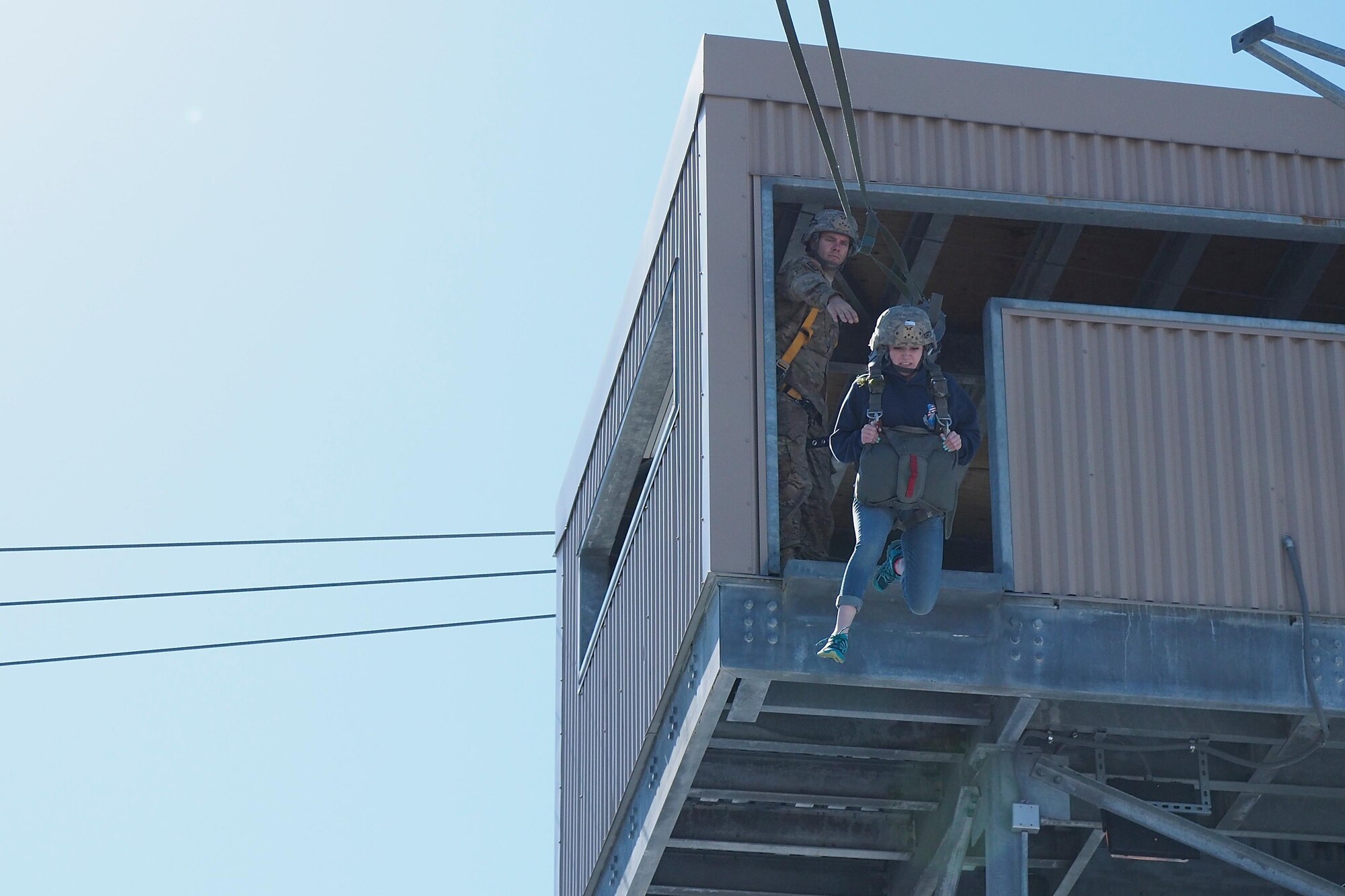 Eagle River High School Air Force Junior ROTC Cadet Riley Sheldon exits a 34-foot jump tower April 19, 2017, at the Joint Base Elmendorf-Richardson Airborne Sustainment Training Area. Sheldon is the daughter of Sgt. Maj. Ronald Sheldon, the 673d Air Base Wing sergeant major. 