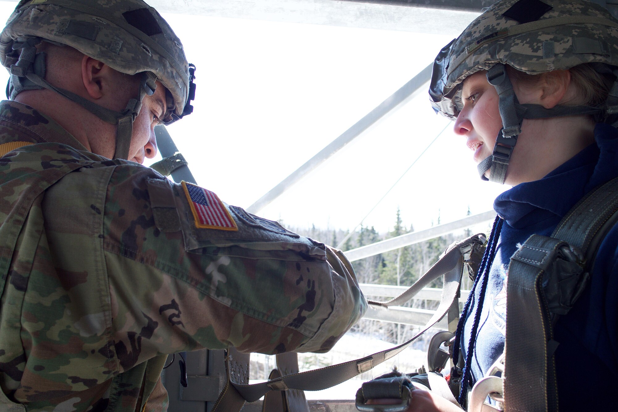 Army Staff Sgt. Raymond Rodriguez, a Miami native and section leader in Delaware Company, 1st Battalion, 501st Parachute Infantry Regiment, rigs Eagle River High School Air Force Junior ROTC Cadet Megan Hancox before the high school student jumps from a 34-foot jump tower April 19, 2017, at the Joint Base Elmendorf-Richardson Airborne Sustainment Training Area. The jump tower simulates the procedures of exiting an aircraft as well as the opening shock of a parachute. 