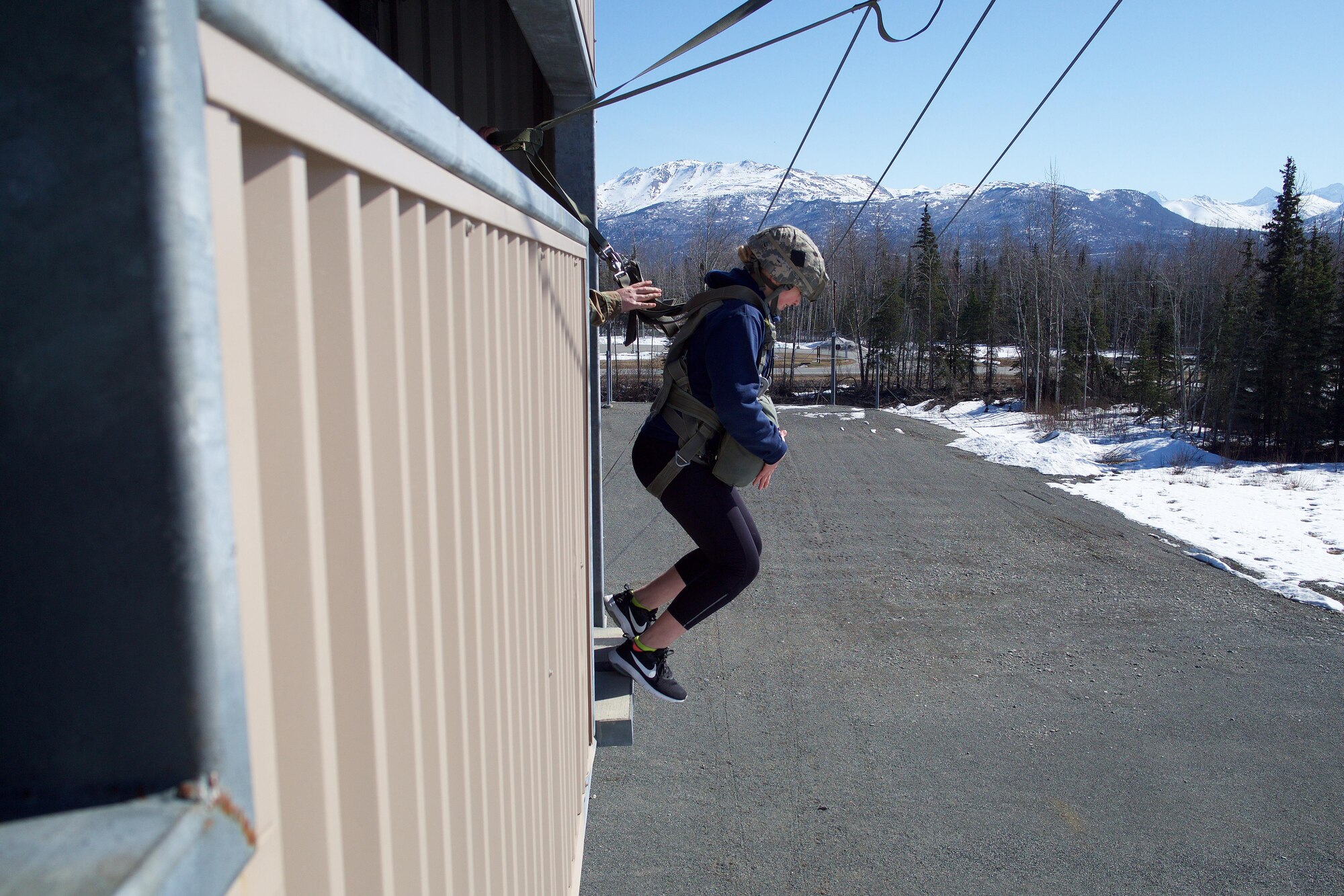 Eagle River High School Air Force Junior ROTC Cadet Megan Hancox exits a 34-foot jump tower April 19, 2017, at the Joint Base Elmendorf-Richardson Airborne Sustainment Training Area. The jump tower builds a paratrooper's confidence in equipment and training.