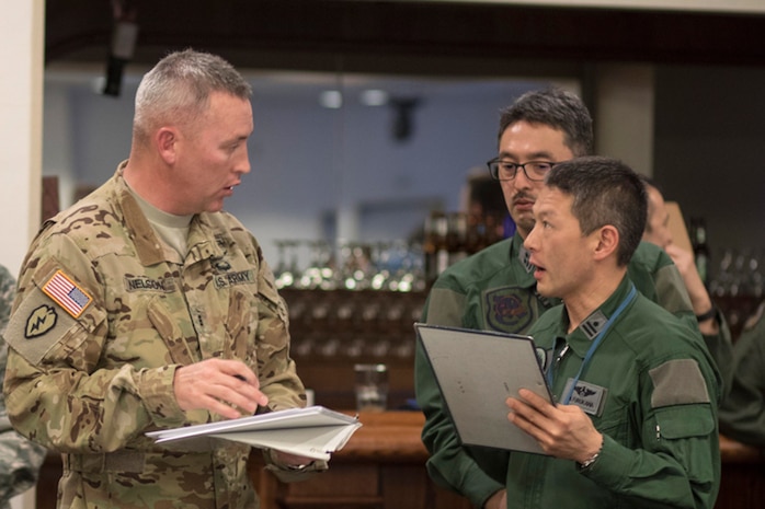 U.S. Army Chief Warrant Officer 3 Teddy Nelson, Army Aviation Battalion Japan UH-60L standardization instructor pilot, answers questions to Japan Air Self-Defense Force members with the Iruma Air Base, during the Kanto Plain Mid-Air Collision and Avoidance Conference, at Yokota Air Base, Japan, April 15, 2017. The conference brought together military and civilian pilots from all over Japan to focus on flight safety and base flight procedures.