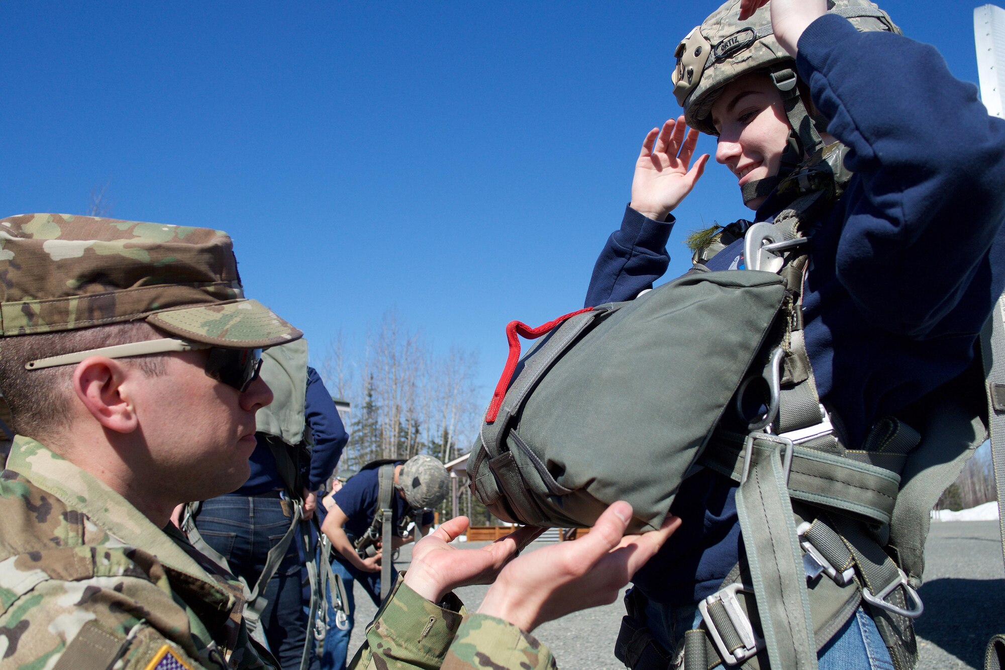 Army 1st Lt. Matthew Sneddon, 1st Battalion, 501st Parachute Infantry Regiment air officer and native of Fayetteville, N.C., inspects Eagle River High School Air Force Junior ROTC Cadet Riley Sheldon before the high school student jumps from a 34-foot jump tower April 19, 2017, at the Joint Base Elmendorf-Richardson Airborne Sustainment Training Area. Many of the same safety checks used for an actual parachute jump are used for jump tower training. Sheldon is the daughter of Sgt. Maj. Ronald Sheldon, the 673d Air Base Wing sergeant major. 