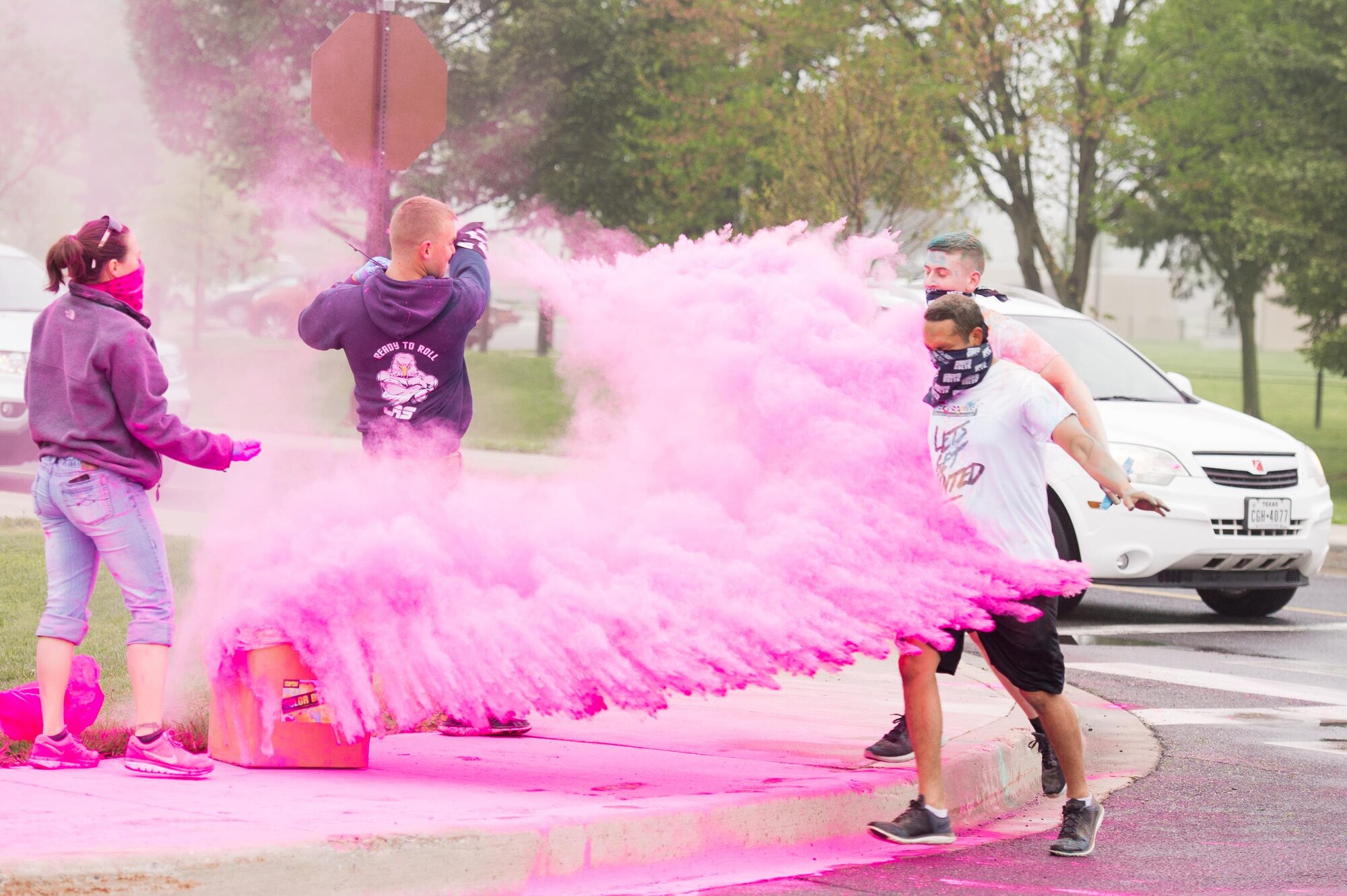 Course volunteers throw pink colored powder on runners during the Sexual Assault Awareness Month Color Run April 21, 2017, at Dover Air Force Base, Del. The event was aimed at raising awareness of sexual assault and to reinforce “protecting our people protects our mission.” (U.S. Air Force photo by Mauricio Campino)