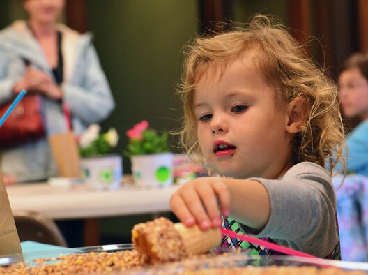 SCHRIEVER AIR FORCE BASE, Colo.-- Annie Canaan rolls her greased ice cream cone in birdseed to create a bird feeder during Tierra Vista Communities’ annual Earth Day celebration at Schriever Air Force Base, Colorado, Friday, April 21, 2017. Attendees also dug for earthworms, decorated flowerpots and picked up seed packets to kick start their home gardens. (U.S. Air Force photo/Brian Hagberg)