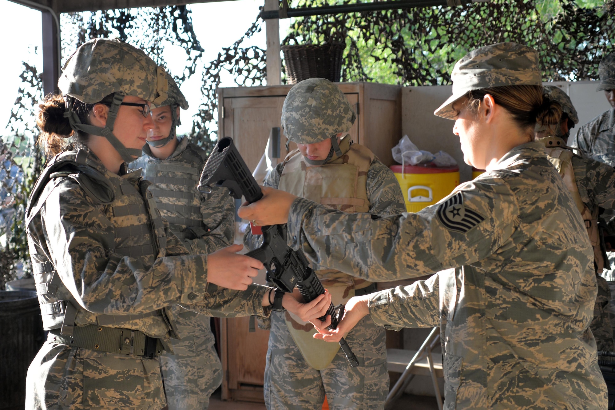 U.S. Air Force Tech. Sgt. Christina Rucoba, 316th Training Squadron instructor, gives a M4 Carbine to an Angelo State University Air Force ROTC Detachment 847 Cadet during a field training exercise at Camp Sentinel on Goodfellow Air Force Base, Texas, April 21, 2017. Instructors taught the cadets how to properly hold and use the rifles. (U.S. Air Force photo by Airman 1st Class Randall Moose/Released)