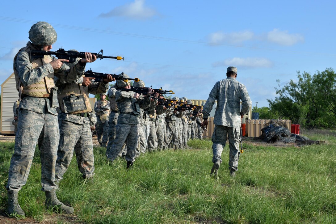 U.S. Air Force Staff Sgt. Philips Dixion, field training exercise instructor, teaches cadets how to properly hold and aim a M4 Carbine during a field training exercise at Camp Sentinel on Goodfellow Air Force Base, Texas, April 21, 2017. The cadets and their adversaries used blanks to simulate a combat enviroment. (U.S. Air Force photo by Airman 1st Class Randall Moose/Released)
