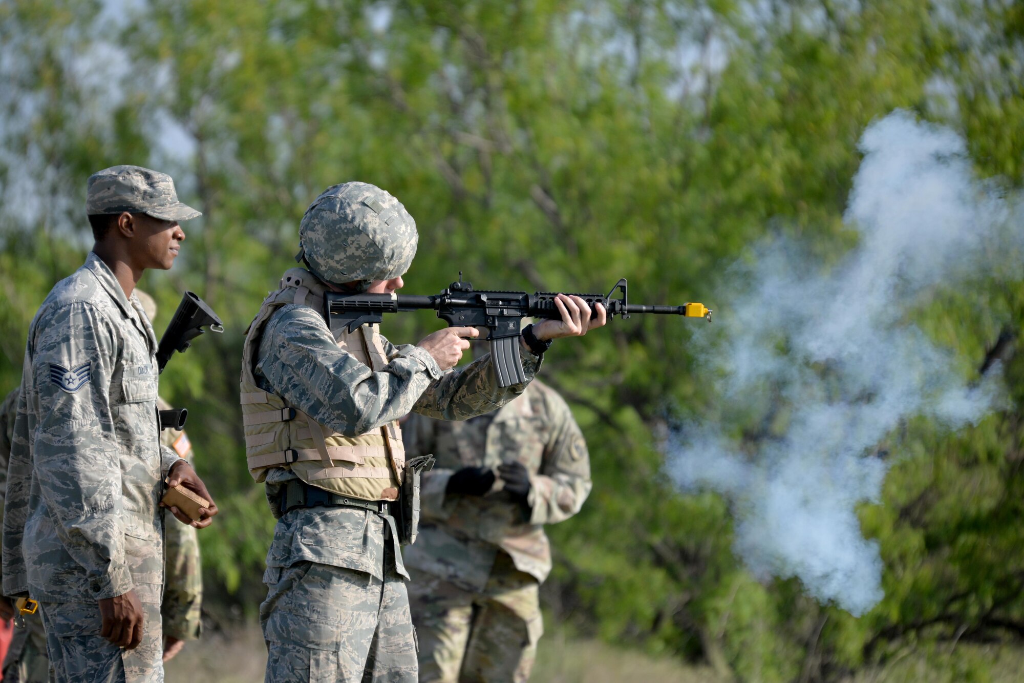 U.S. Air Force Staff Sgt. Philips Dixion, field training exercise instructor, teaches a cadet how to properly hold and aim a M4 Carbine during a field training exercise at Camp Sentinel on Goodfellow Air Force Base, Texas, April 21, 2017. The cadets and their adversaries used blanks to simulate a combat enviroment. (U.S. Air Force photo by Airman 1st Class Randall Moose/Released)