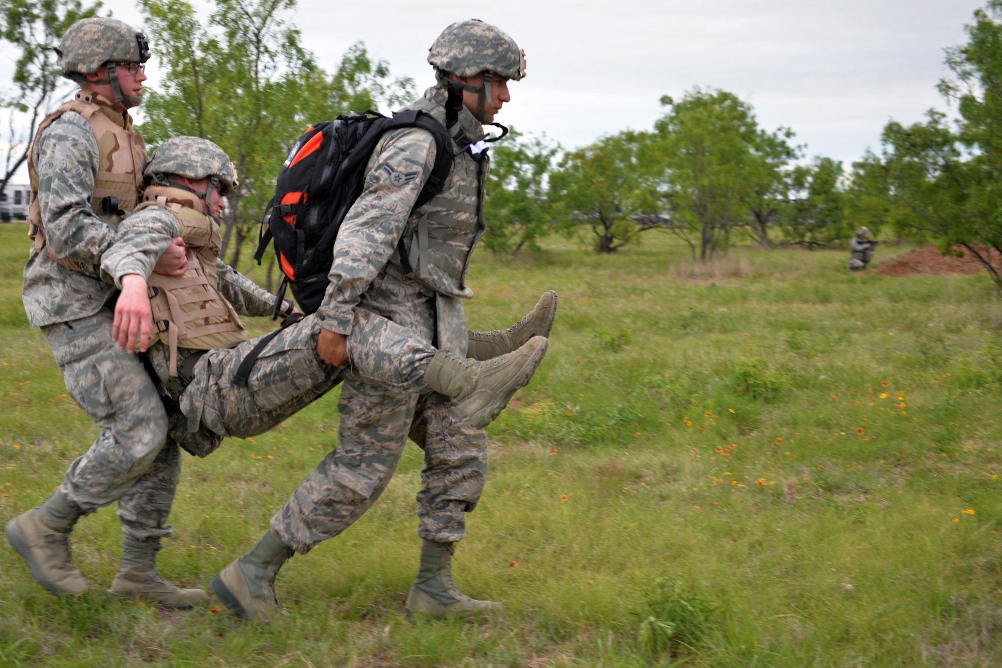 Two Angelo State University Air Force ROTC Detachment 847 Cadets carry a “wounded” Airman after encountering an Improvised Explosve Device during a field training exercise at Camp Sentinel on Goodfellow Air Force Base, Texas, April 22, 2017. During the first half of day-one, the cadets learned a variety of skills to include Self-Aid and Buddy Care, weapon familiarization and leading group movements, which were tested in mock combat conditions. (U.S. Air Force photo by Airman 1st Class Randall Moose/Released)