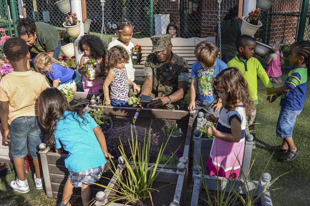 Marine Corps Col. James C. Carroll III, commanding officer of Marine Corps Logistics Base Albany, Ga., works with children at the installation’s Child Development Center to plant and care for flowers as part of an Earth Day observance, April 21, 2017. Marine Corps photo by Verda L. Parker