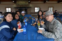 Airmen eat hamburgers for lunch at Sun Plaza Park during sports day April 21, 2017, at Malmstrom Air Force Base, Mont. More than 350 hamburgers were eaten during the burger burn. (U.S. Air Force photo/Airman 1st Class Daniel Brosam)