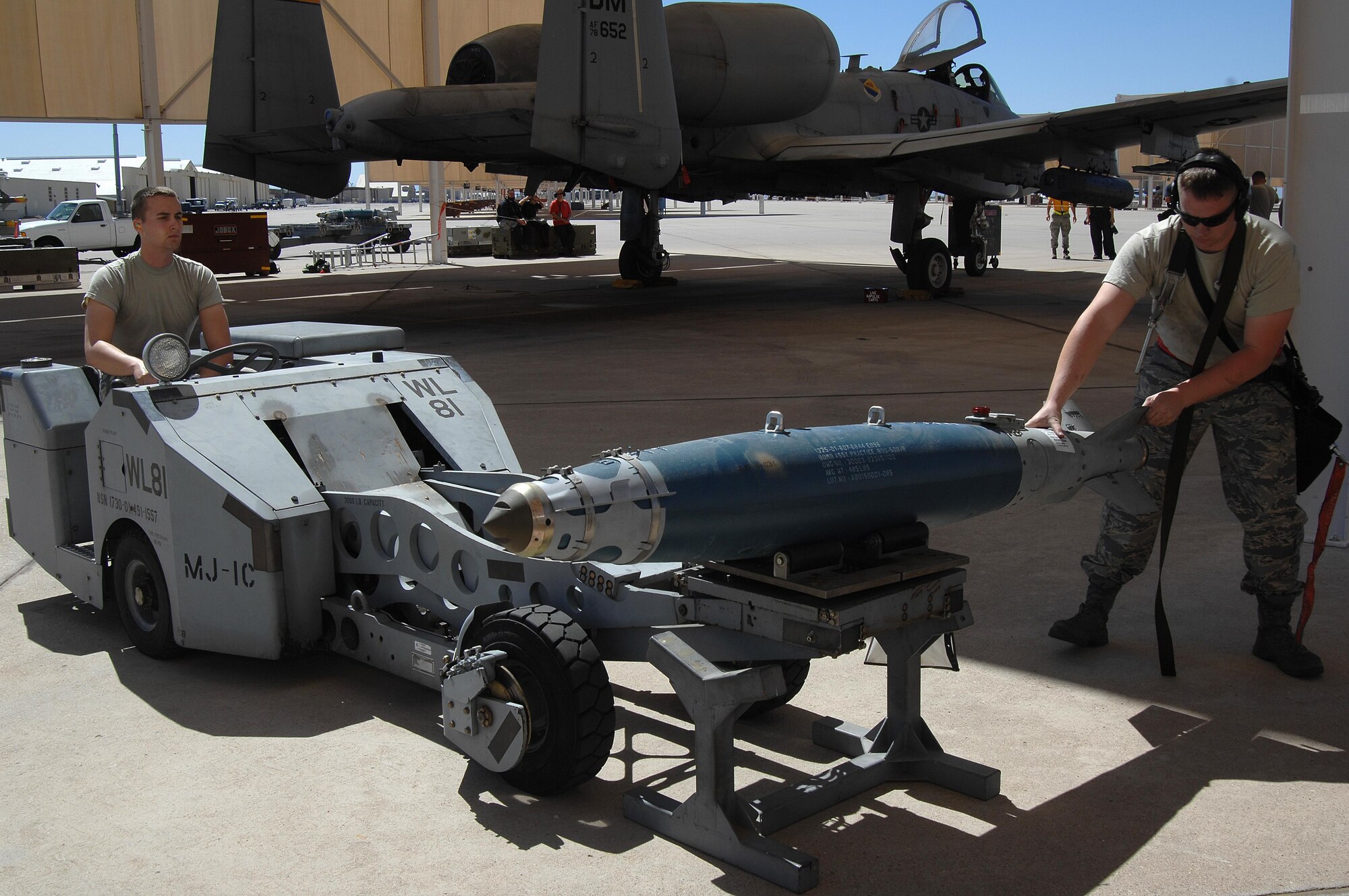U.S. Air Force Airman 1st Class Zachary Rhodes and Staff. Sgt. Christopher Ouellet, 357th Aircraft Maintenance Unit load crew team members, prepare to load a Guided Bomb Unit-38 onto an A-10C Thunderbolt II during a load crew of the quarter competition at Davis-Monthan Air Force Base, Ariz., April 21, 2017. The load crews were required to complete their assigned tasks in accordance with their technical orders in the least amount of time possible. (U.S. Air Force photo by Airman 1st Class Frankie D. Moore)