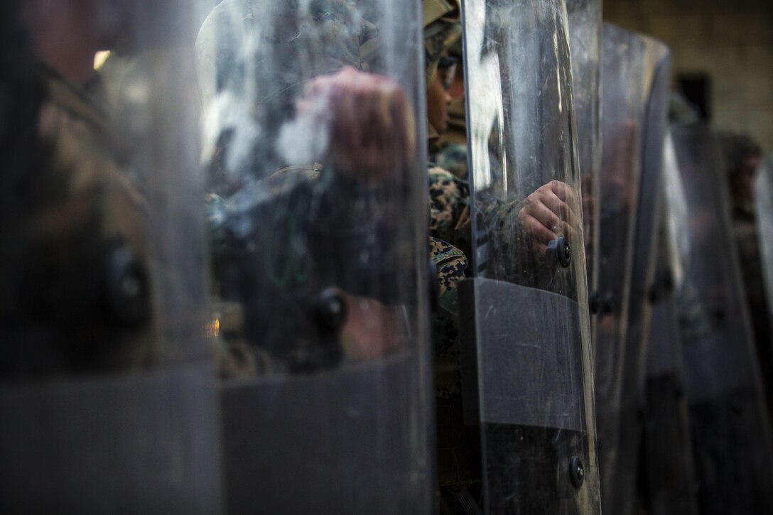 Marines train for riot prevention at Central Training Area, Camp Hansen, April 18, 2017. The battalion conducted a Marine Corps Combat Readiness Evaluation to test each company’s ability to execute tasks ranging from policing operations to police patrolling, route regulations, key leader engagements in towns and local population centers, security of key infrastructure, identity operations and law enforcement operations in an expeditionary environment, to ensure it is prepared to support the operational requirements of III Marine Expeditionary Force. The Marines are with Charlie Company, 3d LE Bn., III Marine Expeditionary Force Headquarters Group, III MEF. (U.S. Marine Corps photo by Lance Cpl. Joshua Pinkney)