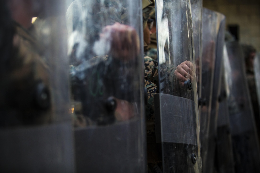 Marines train for riot prevention at Central Training Area, Camp Hansen, April 18, 2017. The battalion conducted a Marine Corps Combat Readiness Evaluation to test each company’s ability to execute tasks ranging from policing operations to police patrolling, route regulations, key leader engagements in towns and local population centers, security of key infrastructure, identity operations and law enforcement operations in an expeditionary environment, to ensure it is prepared to support the operational requirements of III Marine Expeditionary Force. The Marines are with Charlie Company, 3d LE Bn., III Marine Expeditionary Force Headquarters Group, III MEF. (U.S. Marine Corps photo by Lance Cpl. Joshua Pinkney)