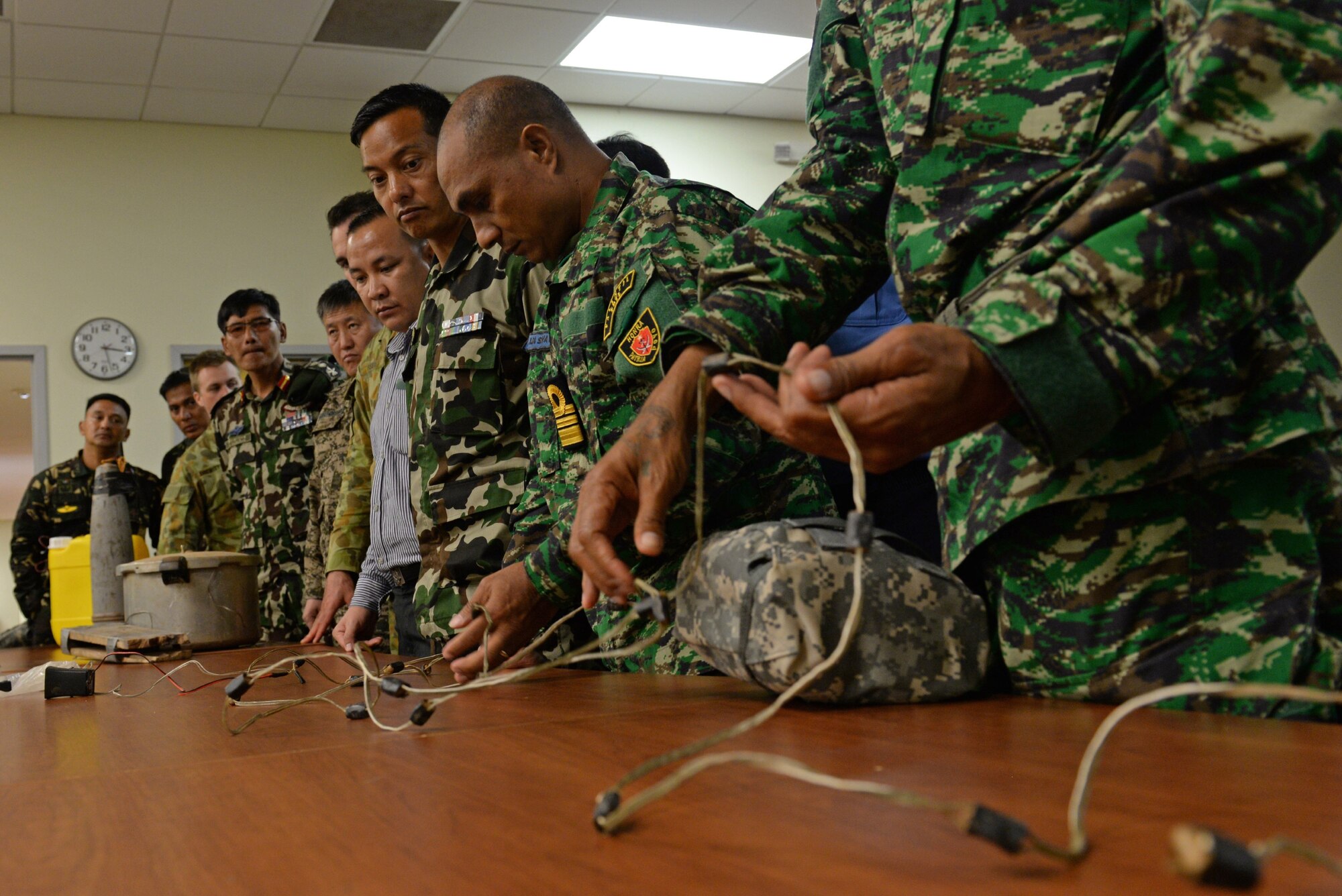 Subject-matter experts from eight different countries examine a mock improvised explosive device during exercise Pacific Defender 17-1, April 11, 2017, at Andersen Air Force Base, Guam. Pacific Defender focuses on tactics, techniques and procedures designed to increase partnerships between participating countries. (U.S Air Force photo by Airman 1st Class Gerald R. Willis/Released)