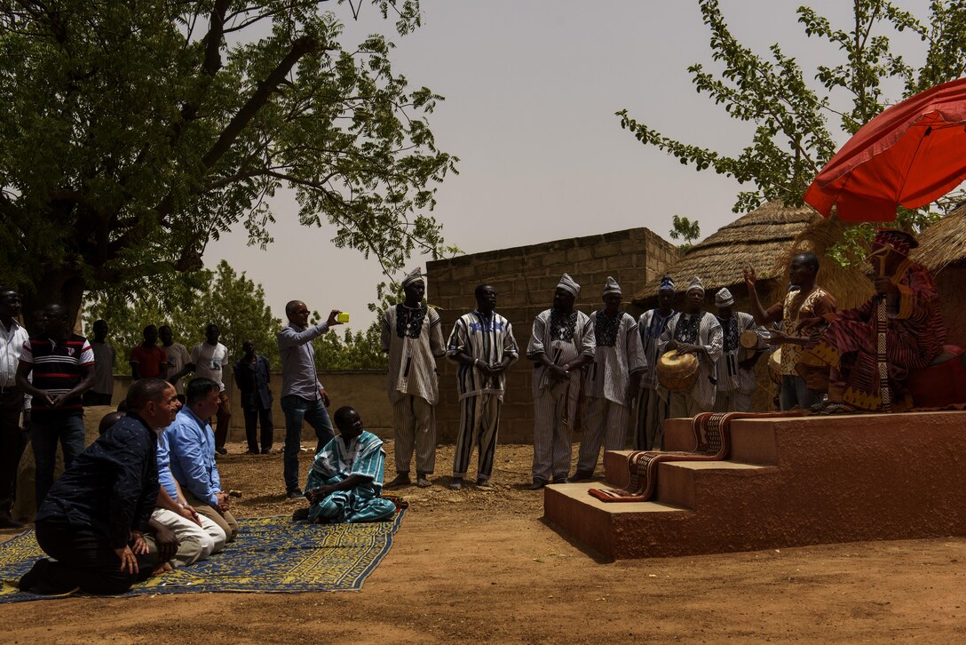 Participants of the African Partnership Flight greet Titinga Frédéric Pacéré during a cultural tour near Ouagadougou, Burkina Faso, April 17, 2017. Pacéré is the founder and curator of the Musee de Manega museum preserving local Burkina traditions. (U.S. Air Force photo by Staff Sgt. Jonathan Snyder) 