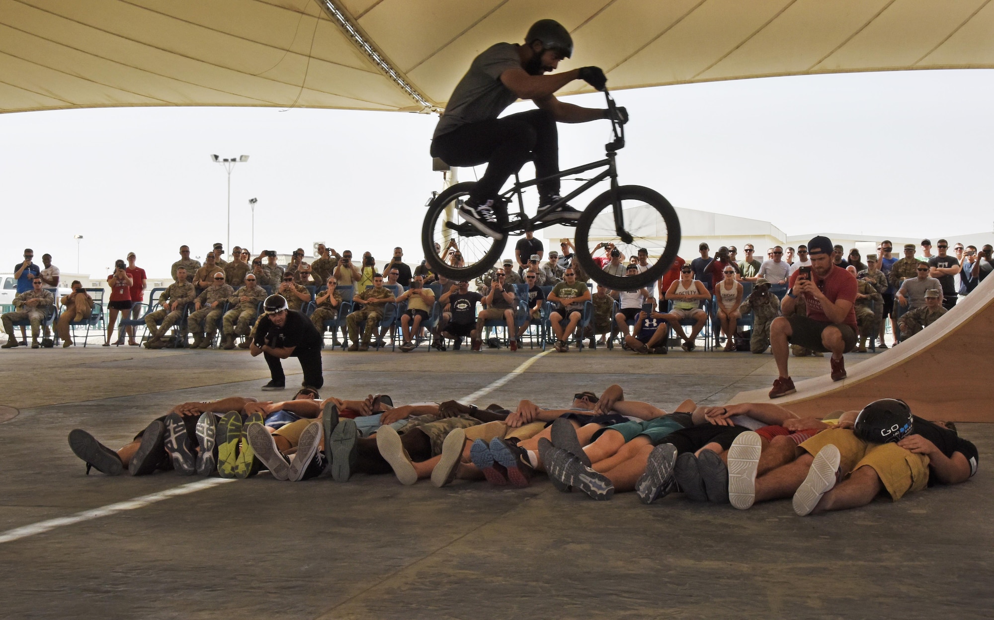 Mykel Larrin, a Bikes Over Baghdad BMX rider, jumps over service members at Al Udeid Air Base, Qatar, April 20, 2017. Bikes Over Baghdad is a professional team of BMX Riders who travel throughout the U.S. Central Command area of responsibility putting on shows for service members. (U.S. Air Force photo by Senior Airman Cynthia A Innocenti)