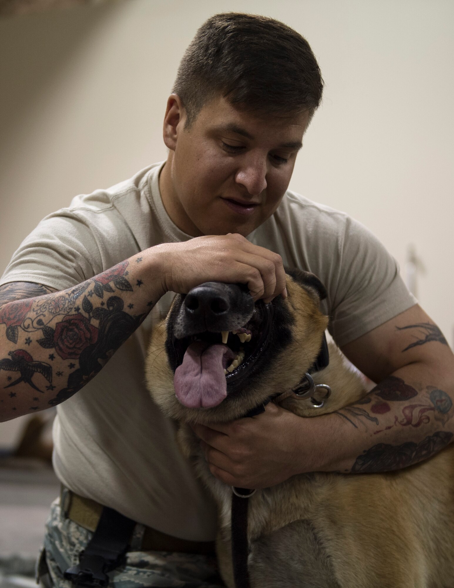 U.S. Air Force Senior Airman Kaleb Sermeno, a military working dog handler with the 379th Expeditionary Security Forces Squadron, helps his military working dog Ben show his healthy gums at Al Udeid Air Base, Qatar, April 19, 2017. U.S. Air Force Airmen from the 379th Expeditionary Aeromedical Evacuation Squadron attended the class in order to gain a better understanding of a military working dog anatomy so they can help in the event that no veterinary medical staff is available. (U.S. Air Force photo by Tech. Sgt. Amy M. Lovgren)