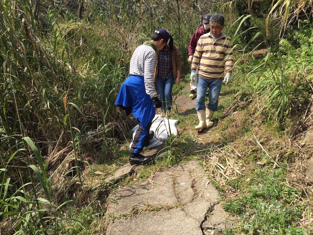 Volunteers work on trail maintenance in the Tawaraga-Uro Cho community as part of a local cleanup effort.