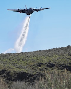 A C130h aircraft loaded with the MAFFS (Modular Airborne Fire Fighting System) from the 152nd Airlift Wing of Reno, Nevada drops a water line while training to contain wildfires just outside Boise, Idaho. April 21, 2017. More than 400 personnel of four C-130 Guard and Reserve units — from California, Colorado, Nevada and Wyoming, making up the Air Expeditionary Group — were in Boise, Idaho for the week-long wildfire training and certification.