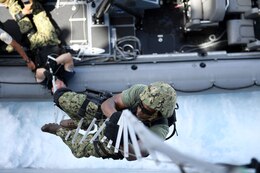 Quartermaster 2nd Class Patrick W. Holmes, assigned to the visit, board, search and seizure (VBSS) team aboard the amphibious dock landing ship USS Carter Hall (LSD 50), climbs up a hook ladder participating in a VBSS drill during exercise Alligator Dagger 17. The exercise provides an opportunity to enhance multilateral capabilities in critical mission sets inherent to the U.S. Navy-Marine Corps, as well as partners and allies in the region. Carter Hall, part of the Bataan Amphibious Ready Group, is deployed to the U.S. 5th Fleet area of operations in support of maritime security operations designed to reassure allies and partners, and preserve the freedom of navigation and the free flow of commerce in the region. 