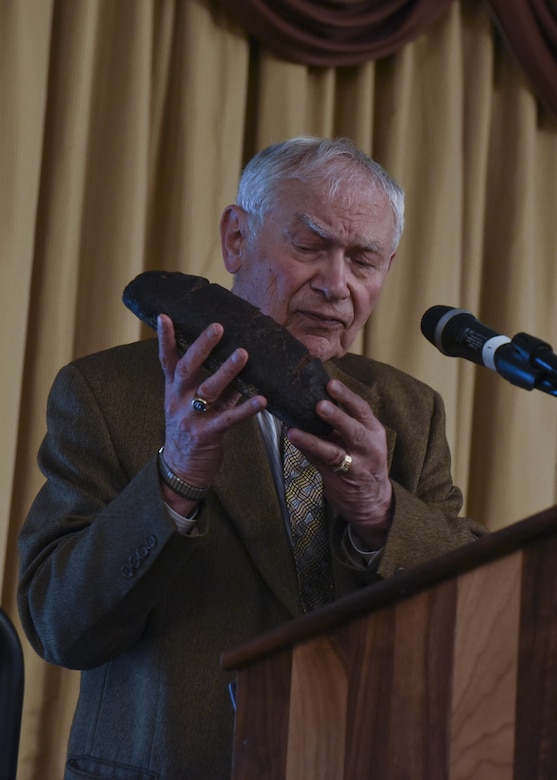 Ernie Gross, a Romanian Holocaust survivor, shows a burnt loaf of bread to a crowd at Joint Base McGuire-Dix-Lakehurst, New Jersey, April 24, 2017. At the Dachau Concentration Camp, a loaf of bread like this would have been split between 5 or more people. 