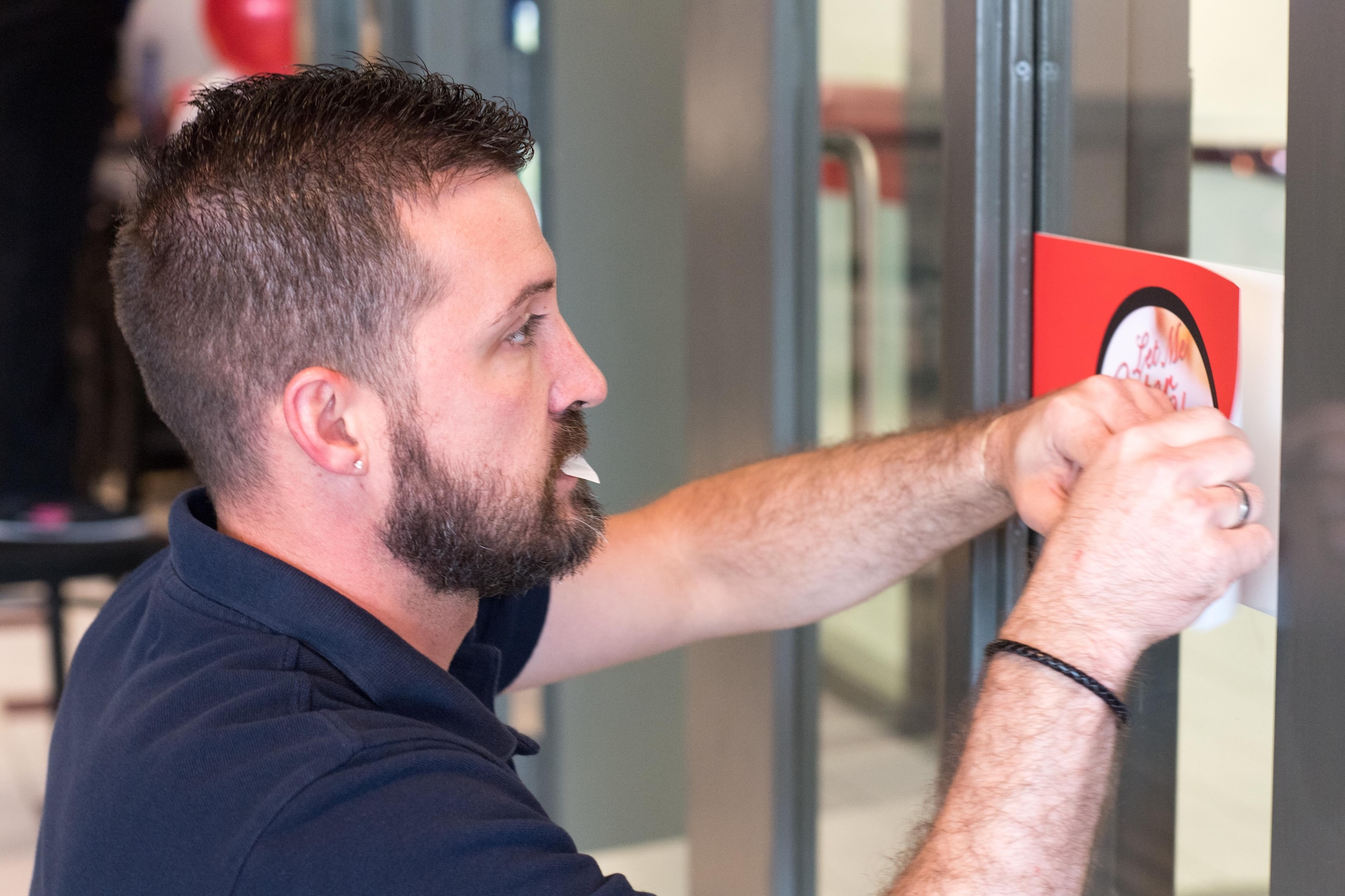 Jason Dellinger, a visual merchandiser with the Fort Bragg Exchange, attaches a grand-opening sign in a new restaurant which held its grand opening at the Airmen's Center here April 7. Open for breakfast and lunch on weekdays, the new veteran-owned restaurant operates similar to military dining facilities, offering service members and civilians convenient access to dining here at Pope. (U.S. Air Force photo/Marc Barnes)