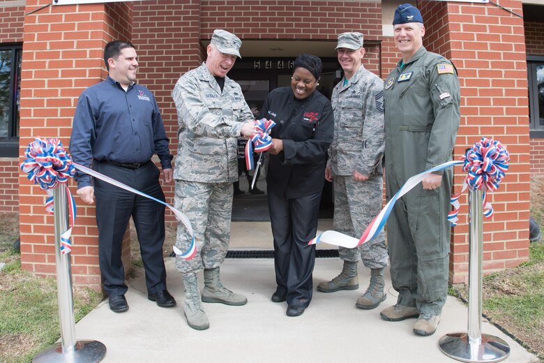 From left to right, Tony Pares, Fort Bragg Exchange general manager; Col. Victor Beeler, 43d Air Mobility Operations Group deputy commander; Chef Judy Cage, owner of Let Me Cater To You; Chief Master Sgt. James Cope, 43d AMOG superintendent; and Col. Kelly Holbert, 43d AMOG commander, celebrate the grand opening of a new restaurant in the Airmen's Center with a ribbon-cutting here April 7. Open for breakfast and lunch on weekdays, the new veteran-owned restaurant operates similar to military dining facilities, offering service members and civilians convenient access to a new dining option at Pope Field. (U.S. Air Force photo/Marc Barnes)