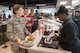 2nd Lt. Brittany O'Brien, 43d Air Base Squadron, pays for her meal at Let Me Cater To You, a new restaurant here at Pope Field, during its grand opening at the Airmen's Center here April 7. Open for breakfast and lunch on weekdays, the new veteran-owned restaurant operates similar to military dining facilities, offering service members and civilians convenient access to dining here at Pope. (U.S. Air Force photo/Marc Barnes)