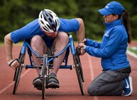 Airman 1st Class John Lemoine, a Warrior Games athlete, receives some help with his sports chair by Teresa Skinner, a Warrior Games trainer, during a morning track and field session at the Air Force team’s training camp at Eglin Air Force Base, Fla., April 24. The base-hosted, week-long Warrior Games training camp is the last team practice session before the yearly competition in June. (U.S. Air Force photo/Samuel King Jr.)