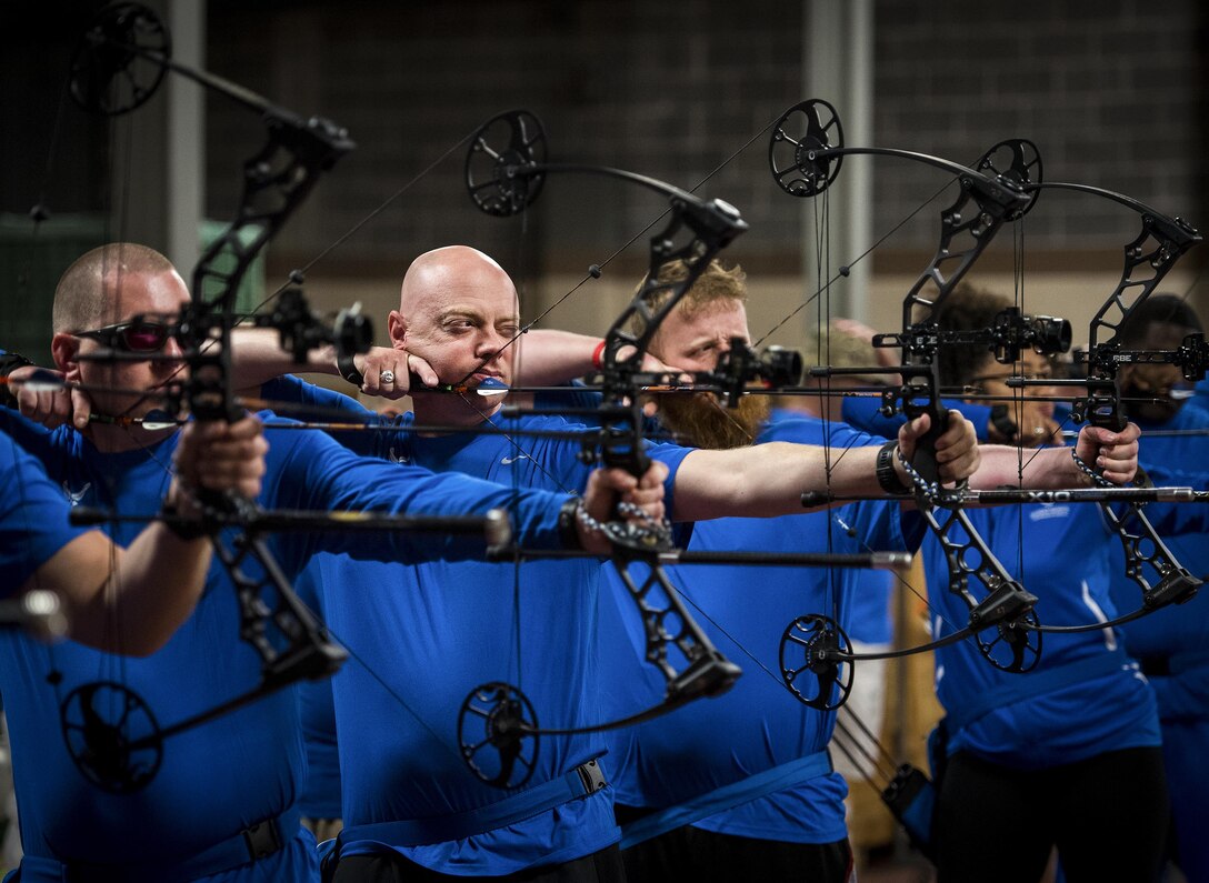 Mark Blinn, a Warrior CARE athlete, aims for a bullseye with his other athletes during an archery session at the adaptive sports camp at Eglin Air Force Base, Fla., April 24. The base hosts the week-long Wound Warrior CARE event that helps recovering wounded, ill and injured military members through specific hand-on rehabilitative training. (U.S. Air Force photo/Samuel King Jr.)