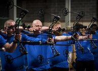 Mark Blinn, a Warrior CARE athlete, aims for a bullseye with his other athletes during an archery session at the adaptive sports camp at Eglin Air Force Base, Fla., April 24. The base hosts the week-long Wound Warrior CARE event that helps recovering wounded, ill and injured military members through specific hand-on rehabilitative training. (U.S. Air Force photo/Samuel King Jr.)