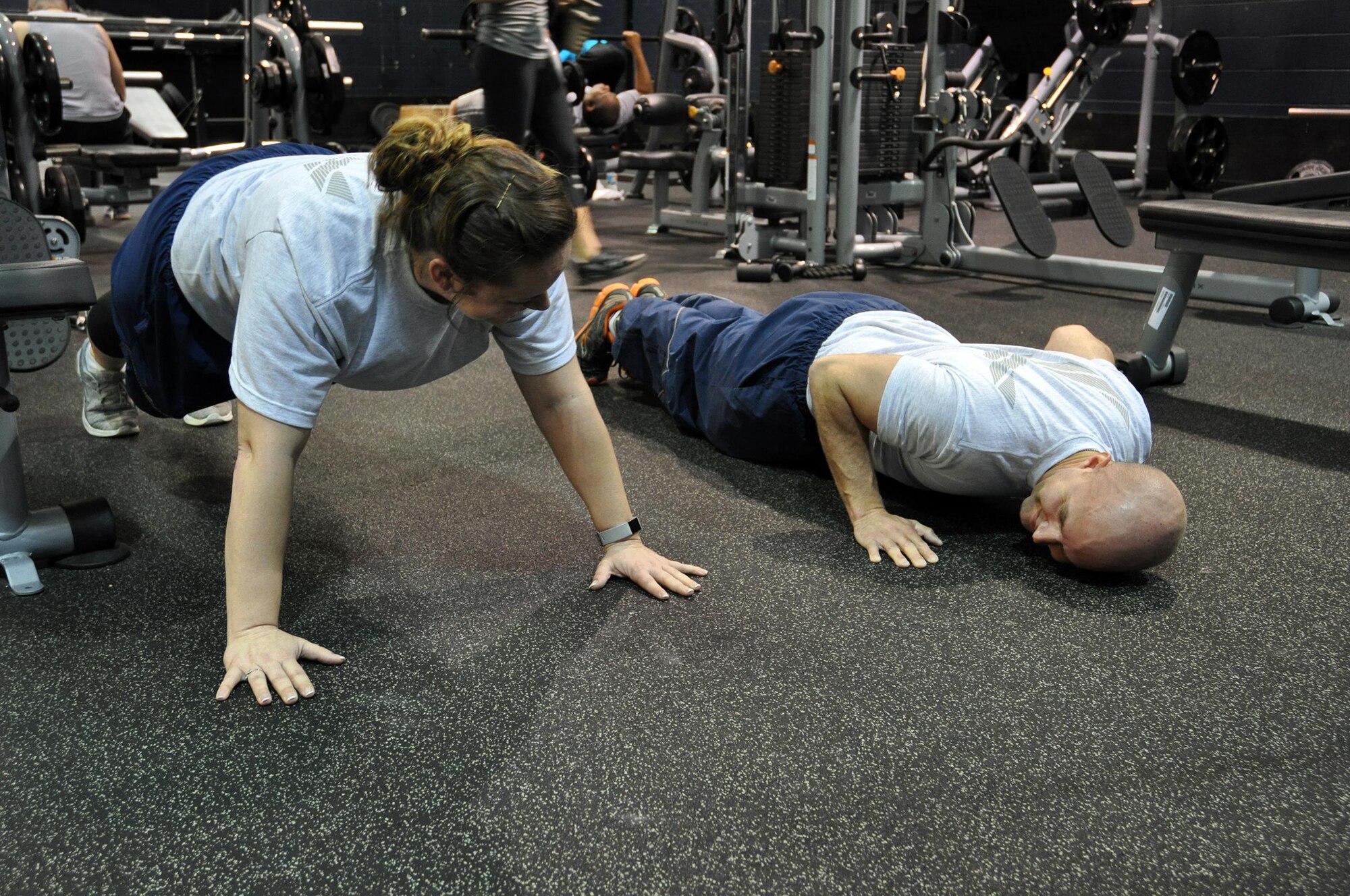 Senior Airman Christian Terrill, 445th Aeromedical Staging Squadron medical technician, demonstrates the proper techniques of doing a push up for Senior Airman Billie Dunigan, also a 445 ASTS member, at Jarvis Gym, April 2, 2017 to improve her core strength following the birth of her child. (U.S. Air Force photo/Tech. Sgt. Rachel Ingram)